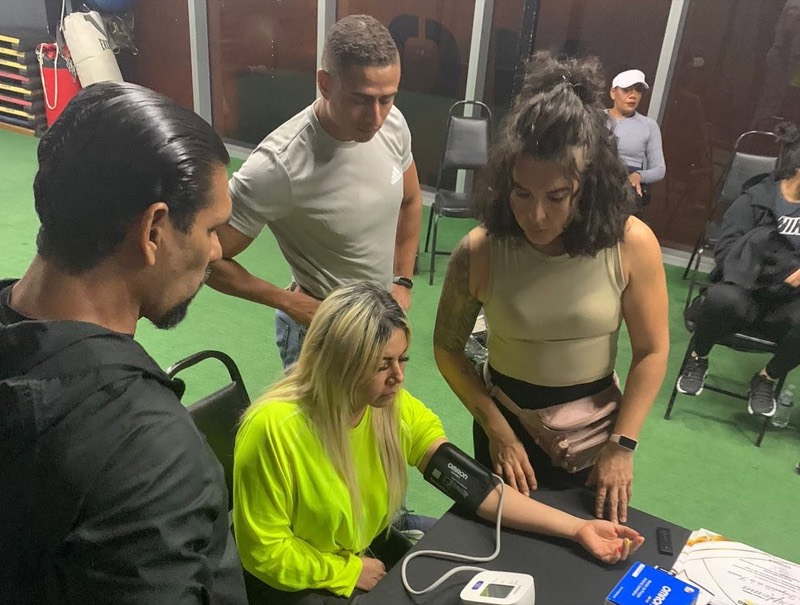 Alumnos aprendiendo a tomar la presión arterial durante una evaluación práctica